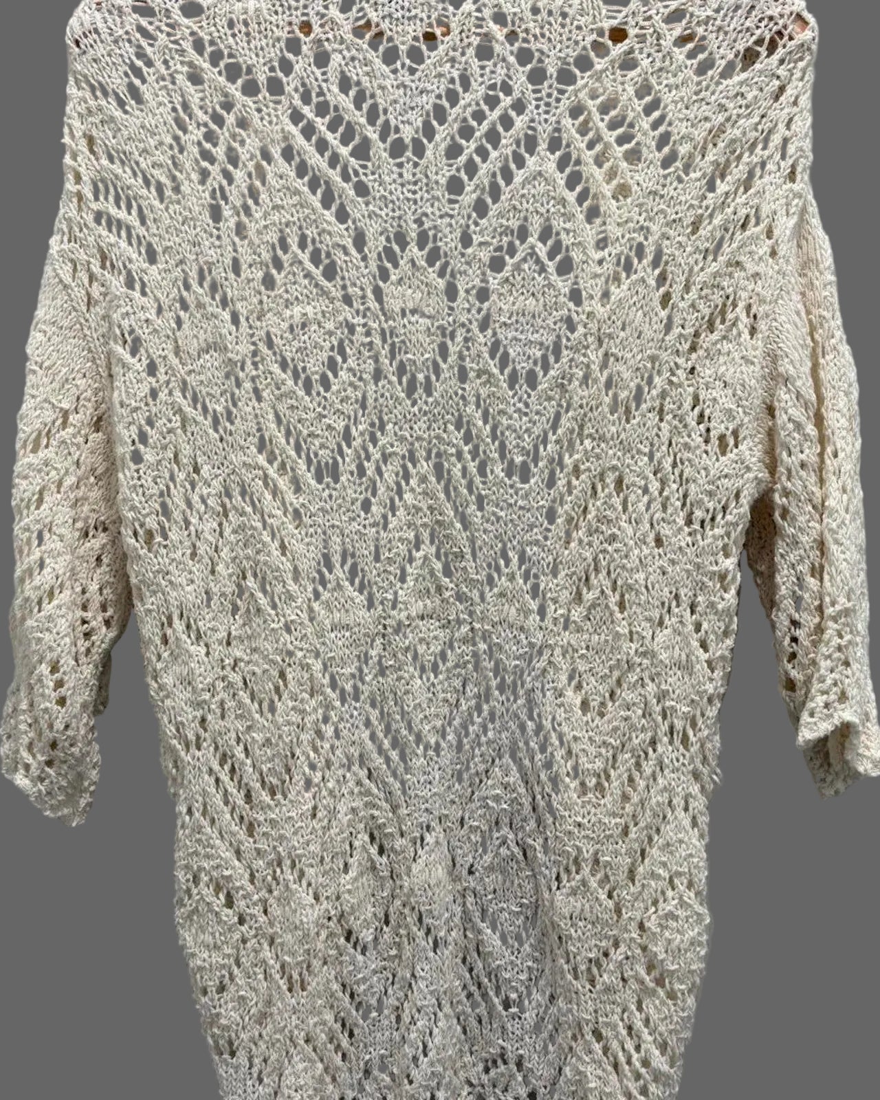 Knitted sweater with a crocheted pattern on a gray background