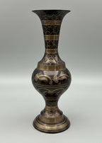 Decorative vase with intricate patterns next to a measuring tape, measuring 9" tall on a grey background.