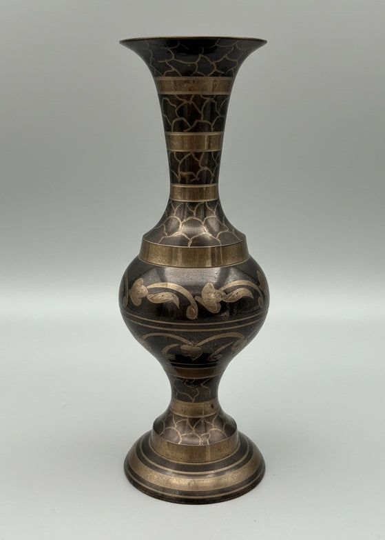 Decorative vase with intricate patterns next to a measuring tape, measuring 9" tall on a grey background.