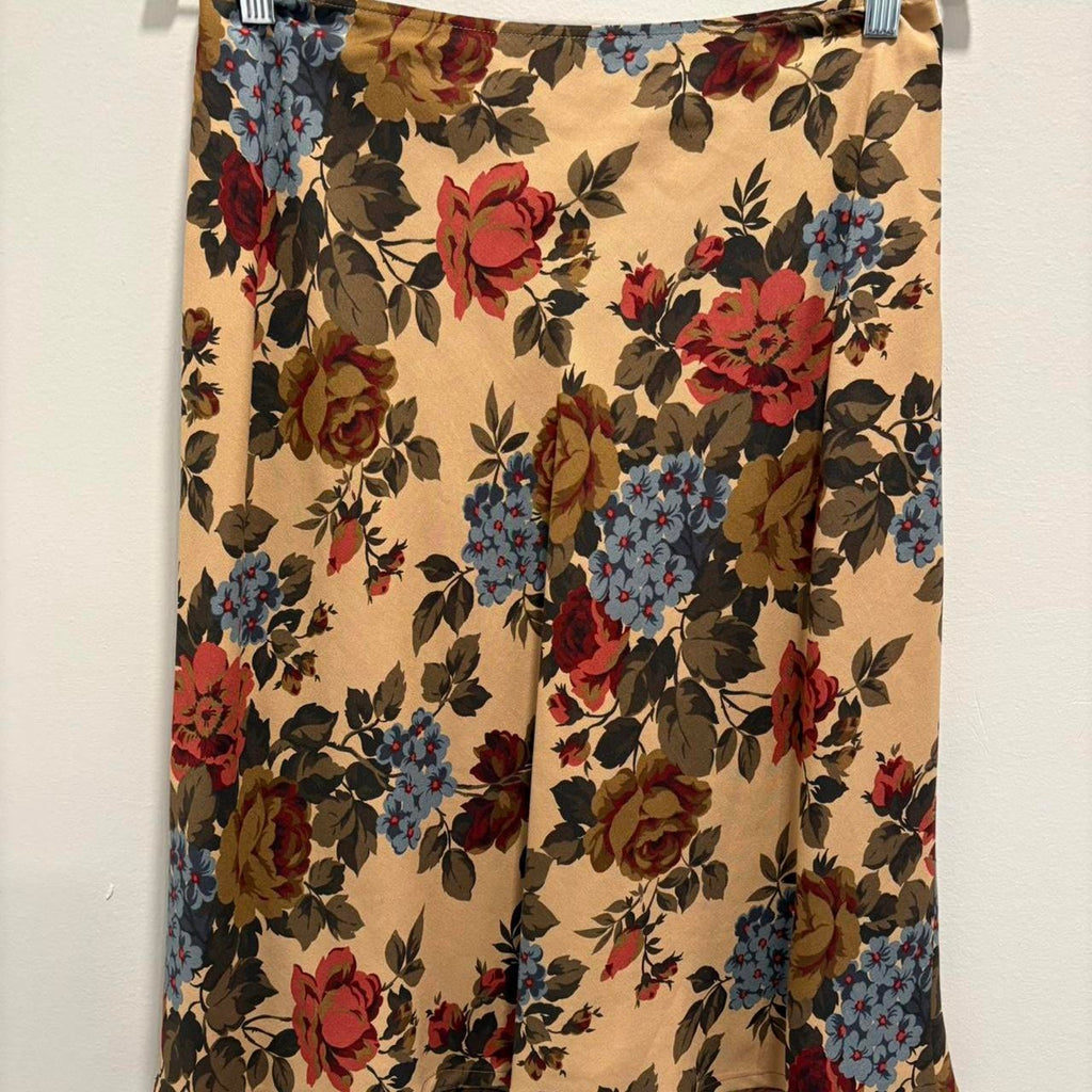 Floral patterned silk skirt hanging against a white background