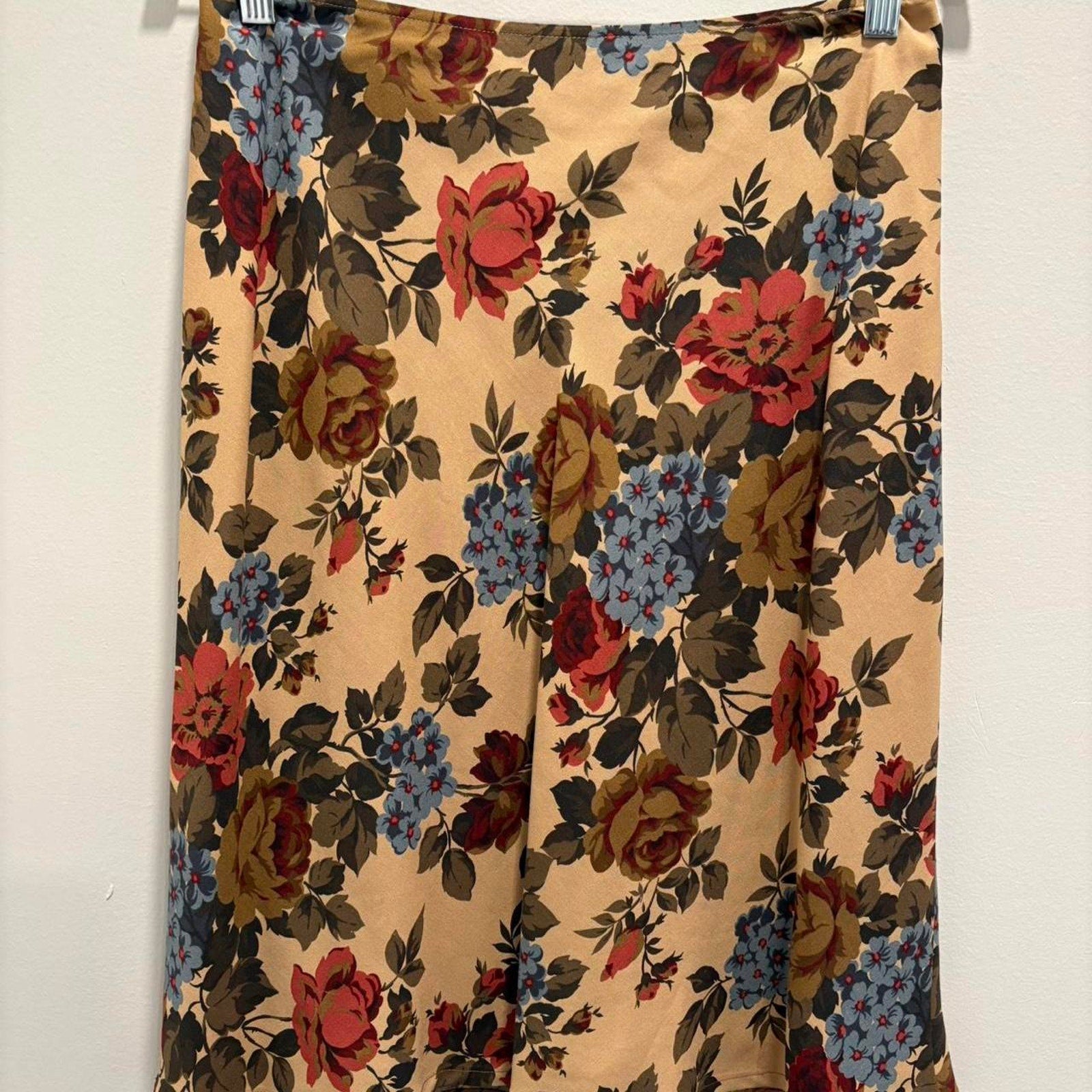 Floral patterned silk skirt hanging against a white background