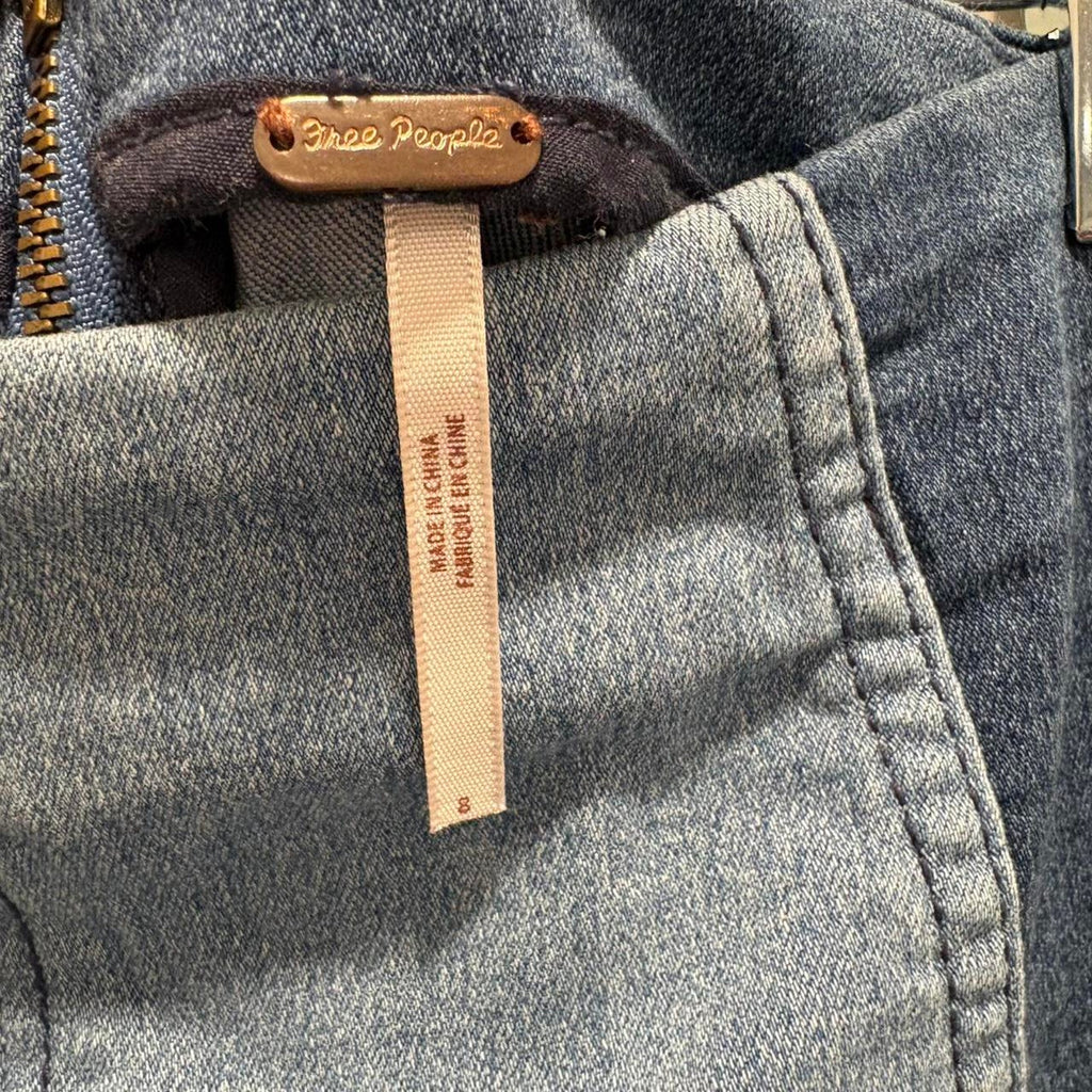 Close-up of a denim label on a denim mini skirt with 'Free People' branding.