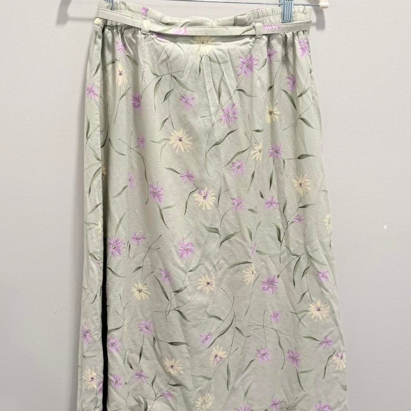 Floral-patterned skirt on a hanger against a plain background
