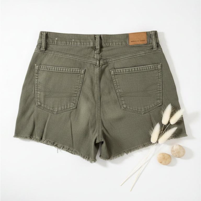 Green denim shorts on a textured surface