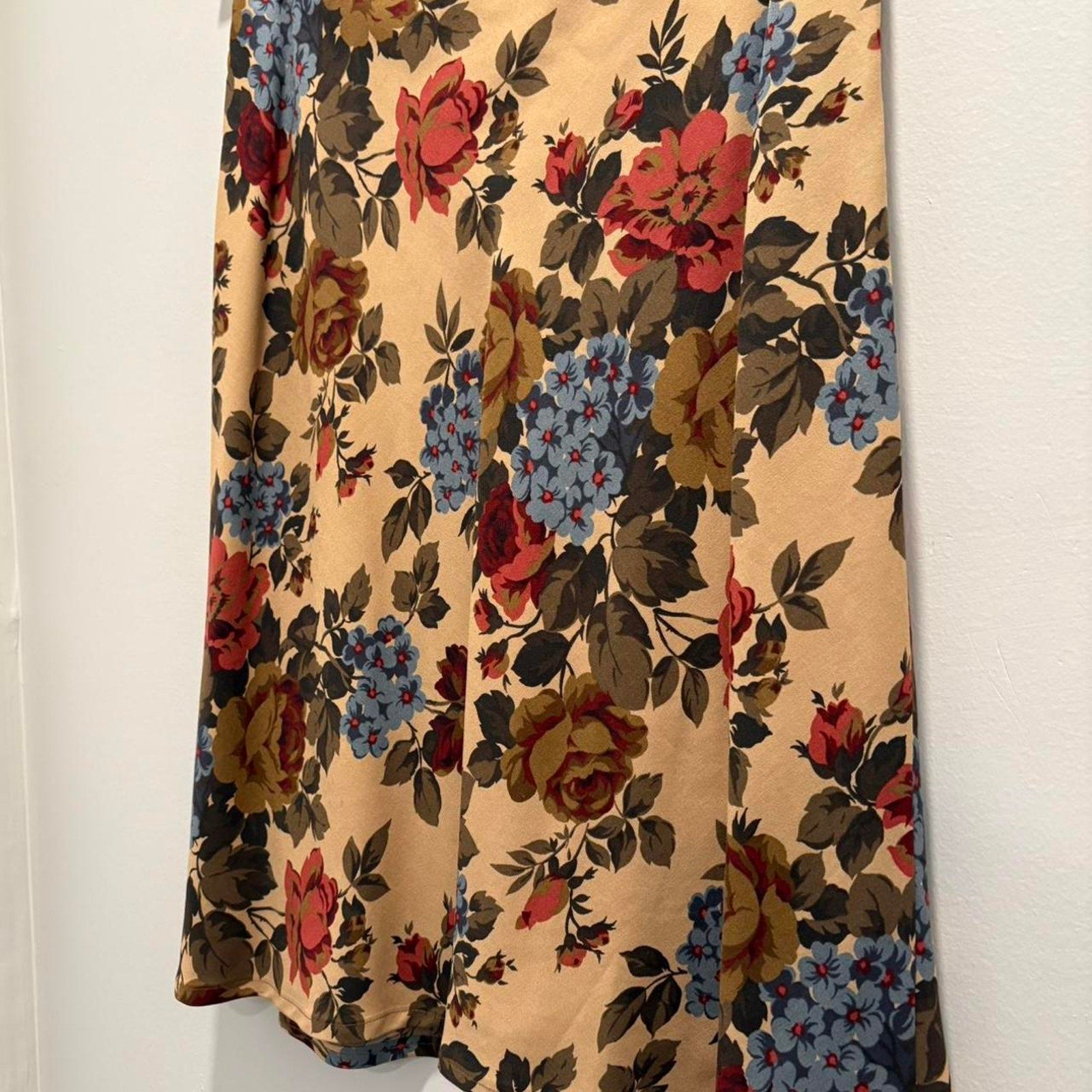 Floral patterned skirt hanging against a white wall