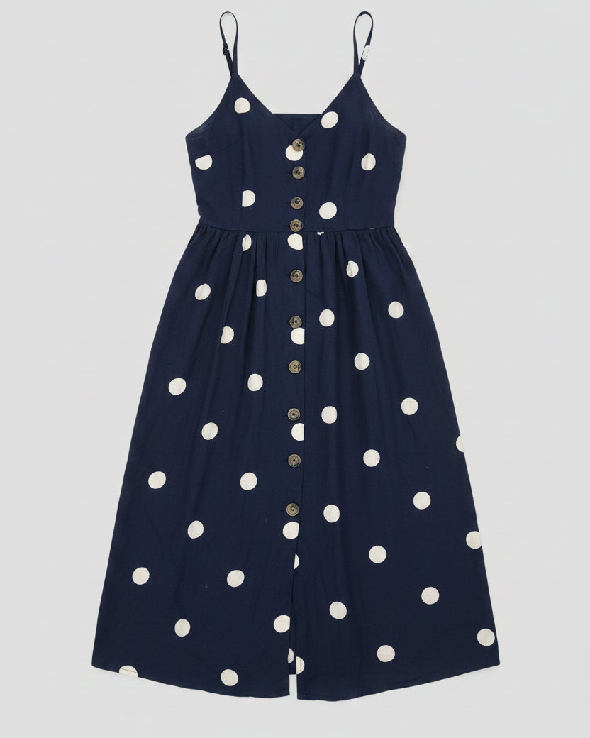 Navy blue dress with white polka dots on a grey background