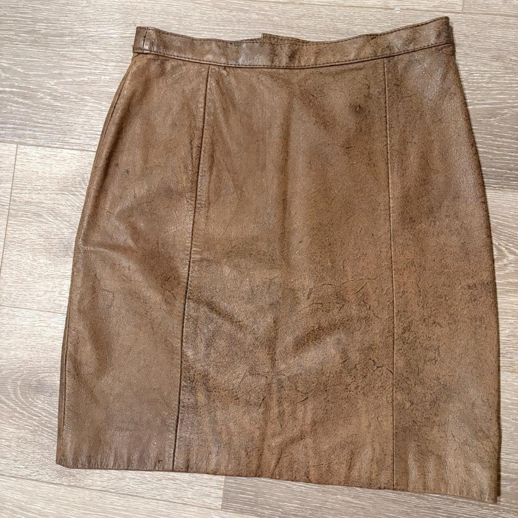 Vintage brown leather skirt on a wooden floor