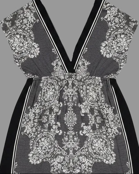 Black dress with white floral pattern on a wooden surface