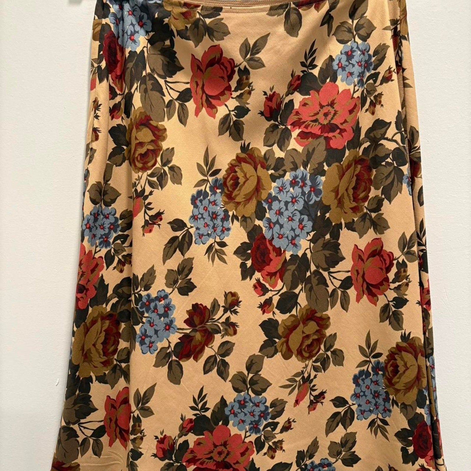 Floral patterned skirt with red, blue, and brown flowers on a beige background