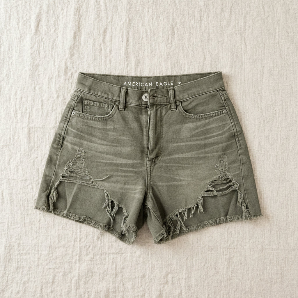 Green denim fringe shorts with a 'American Eagle' label on a textured surface